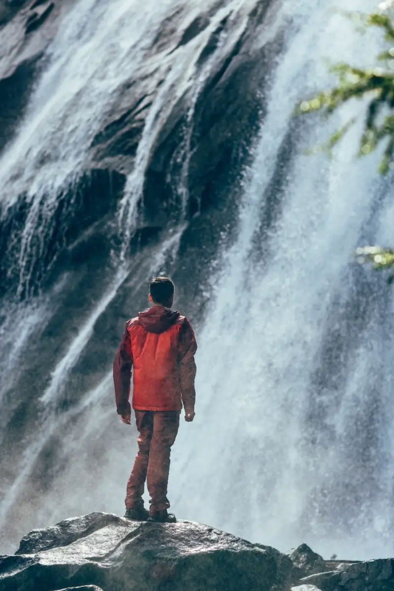 Man seeks self awareness at foot of waterfall